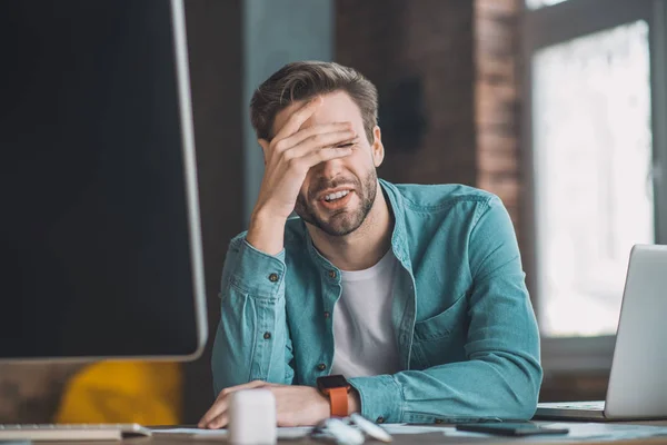 Trauriger fröhlicher Mann, der über seine Arbeit nachdenkt — Stockfoto