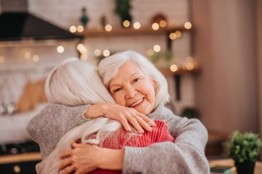 Two mature grey-haired positive ladies feeling happy