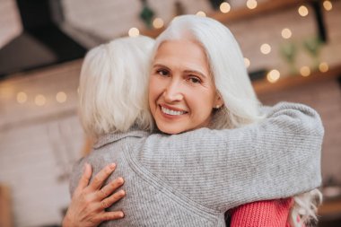 Two mature grey-haired positive ladies looking happy