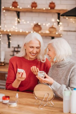 Two good-looking elderly women enjoying skin treatment
