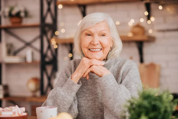 Mooie oudere vrouw in grijze trui voelt zich geweldig — Stockfoto