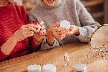 Two good-looking elderly women talking about skin treatment
