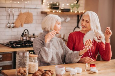 Two good-looking elderly women discussing beauty issues