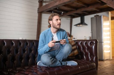 Evde video oyunu oynayan duygusal bir adam.