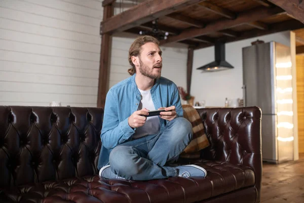 Evde video oyunu oynayan duygusal bir adam.