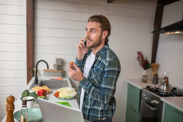 Чоловік робить дзвінок під час приготування їжі — стокове фото