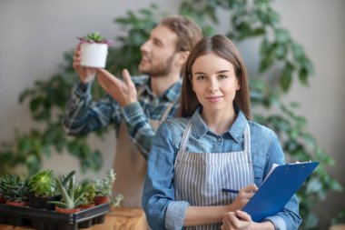 Kendine güveni tam bir kadın bir fabrikada not alıyor.