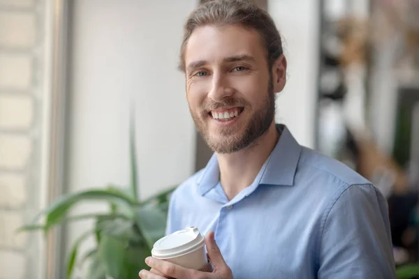 Sorrindo homem confiante segurando uma xícara de café — Fotografia de Stock