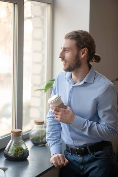 Thoughtful man looking in the window while having coffee — Stock Photo, Image