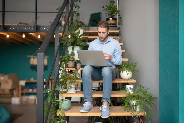 Man met behulp van een computer tijdens het zitten op de trap — Stockfoto