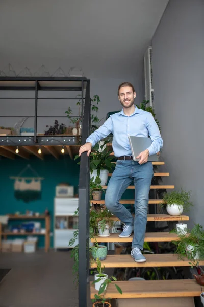 Man die op de beboste trap staat en zijn laptop vasthoudt — Stockfoto