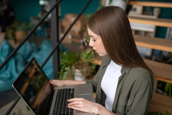 Νεαρή γυναίκα δακτυλογραφεί ένα σημαντικό ταχυδρομείο χρησιμοποιώντας τον υπολογιστή της — Φωτογραφία Αρχείου