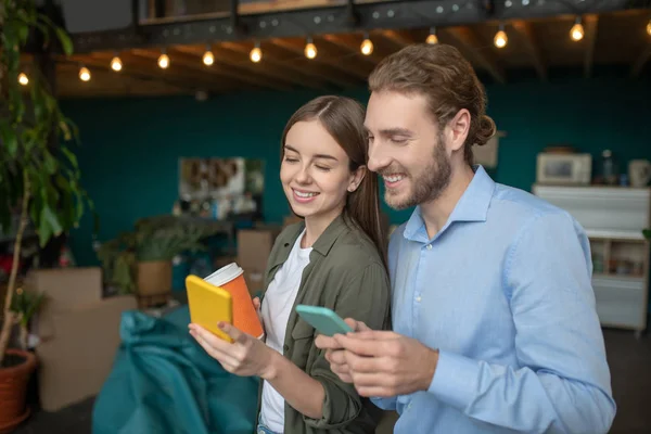 Hombre y una mujer mirando fotos usando un smartphone —  Fotos de Stock