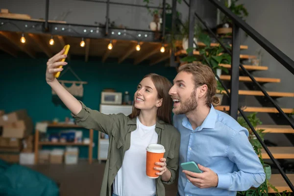 Bir kadın ve bir adam komik bir selfie çekiyorlar.