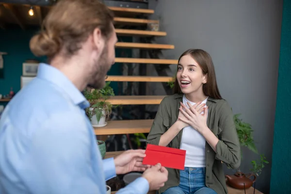 Homme donnant une enveloppe rouge à la femme admirée — Photo