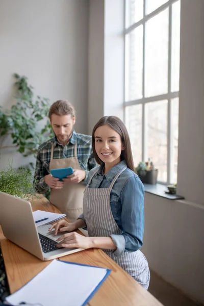 Glimlachende vrouw doet boekhouding voor een online winkel — Stockfoto