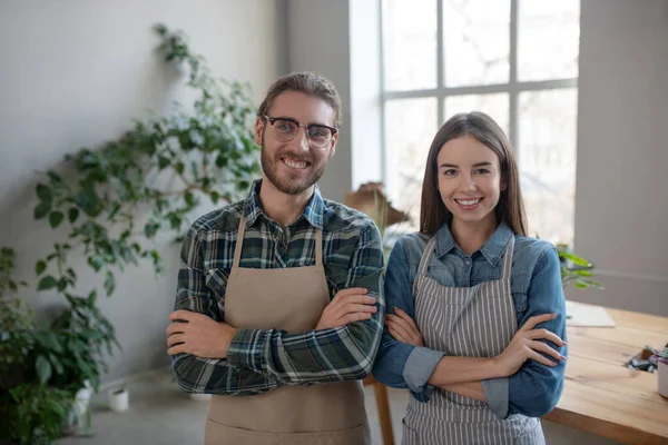 Deux propriétaires de magasins de plantes souriants portant des tabliers — Photo