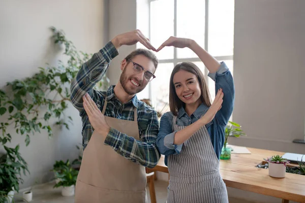 Hombre y mujer haciendo un corazón con sus manos —  Fotos de Stock