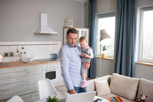 Hombre con una camisa azul de pie junto a la mesa con su hija —  Fotos de Stock