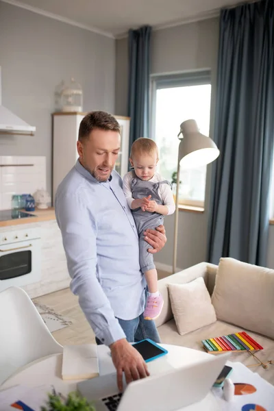 Uomo in camicia blu in piedi e tenendo la sua bambina — Foto Stock