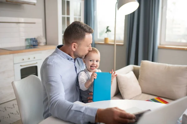 Homme dans une chemise bleue embrassant sa fille bébé — Photo