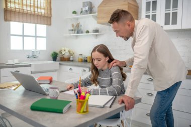 Masanın yanında duran kısa saçlı sakallı adam.