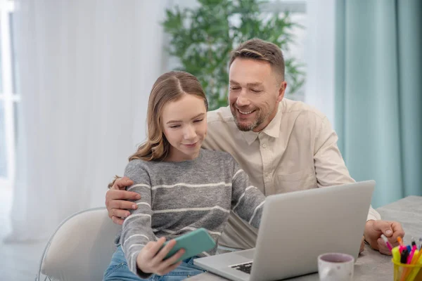 Long-haired girl in grey shirt feeling good with her father — 스톡 사진