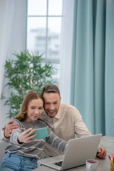 Cute girl in grey shirt and her father making selfie — 스톡 사진