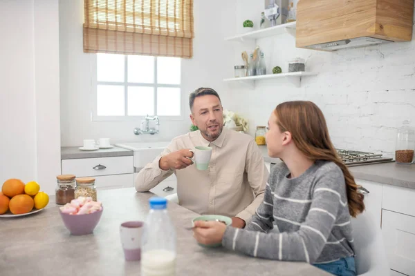 Vater und Tochter unterhalten sich beim Frühstück munter. — Stockfoto