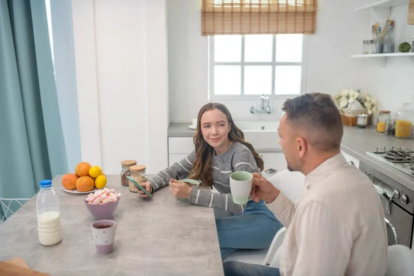 Dad and teen daughter talk at the table after breakfast. — Stock Photo, Image