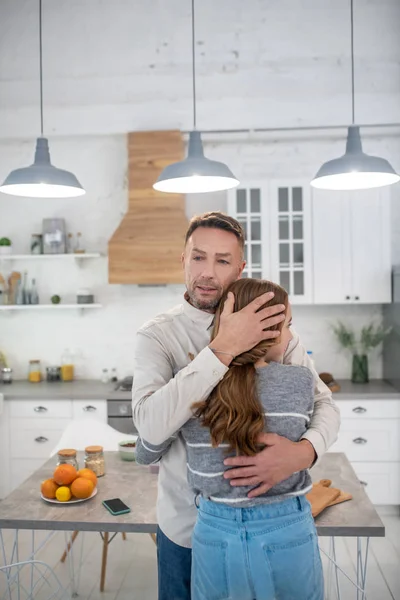 Fürsorglicher Vater umarmt seine Tochter in der Küche. — Stockfoto