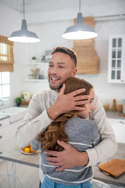 Joyful dad hugging his daughter at home. — Stock Photo, Image