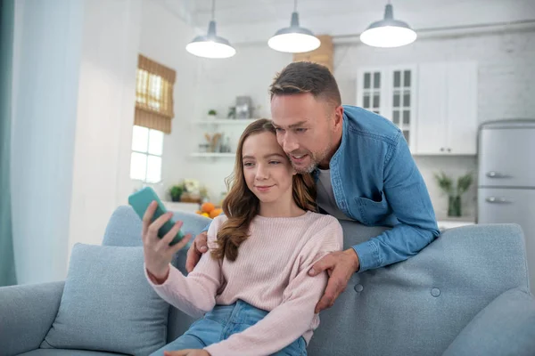 Dad with daughter looking at smartphone screen happy. — Stock Photo, Image