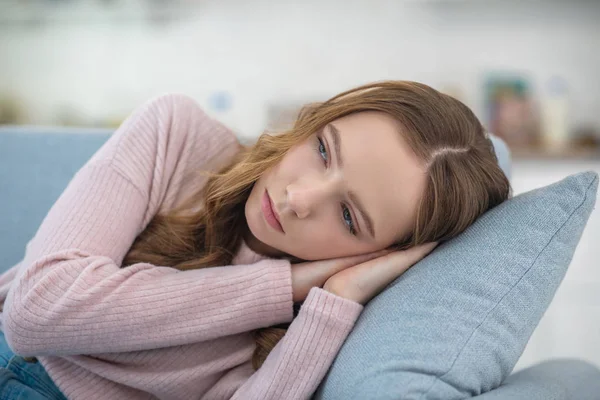 Chica triste acostada en un sofá en casa . — Foto de Stock