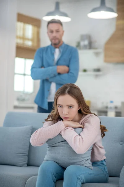 Pai em pé atrás do sofá em que a filha está sentada . — Fotografia de Stock