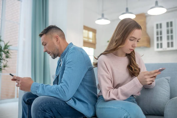 Padre e hija sentados en el sofá uno detrás del otro . —  Fotos de Stock