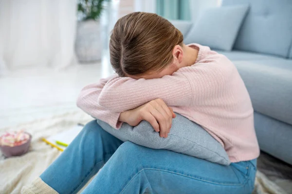 Girl sitting on the floor, head down, hiding her face. — Stock Photo, Image