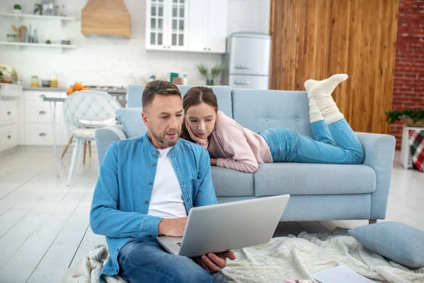 Father and daughter in good mood watching laptop at home. — Stock Photo, Image