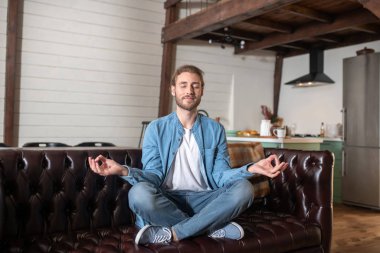Rahat adam koltuğunda otururken meditasyon yapıyor.