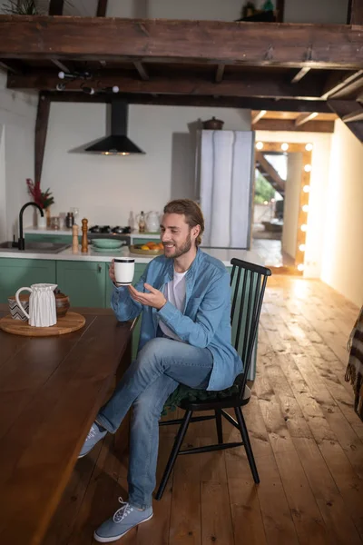 Seorang pria duduk di dapur dan minum teh — Stok Foto