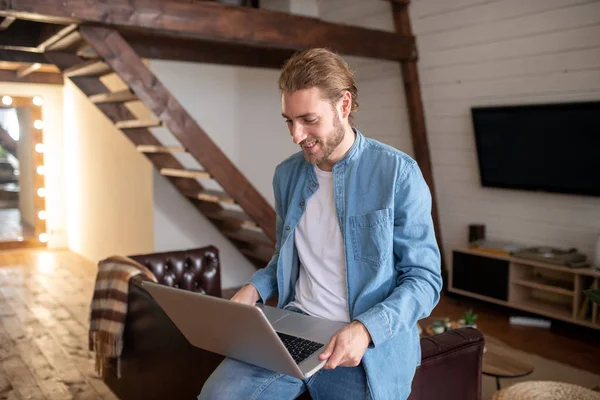 Sorrindo homem trabalhando com seu computador em casa — Fotografia de Stock