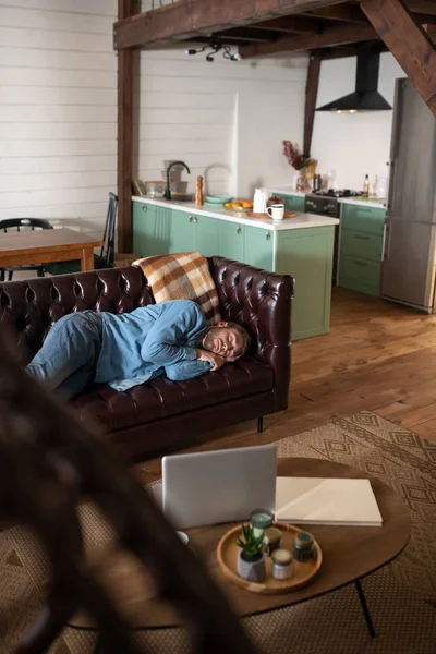 Seorang pria tidur di sofa kulit di rumah — Stok Foto