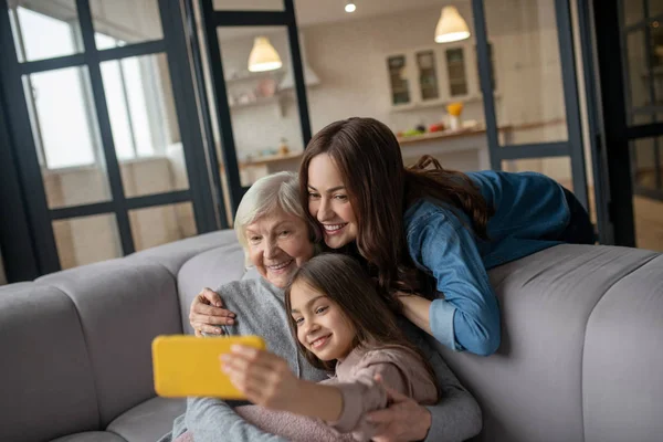 Krama och ta selfie flicka, mamma och mormor. — Stockfoto