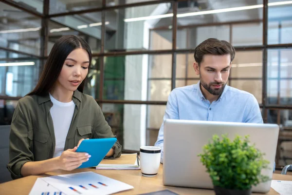 Jong aziatische vrouw hoding een tablet en kijken serieus — Stockfoto