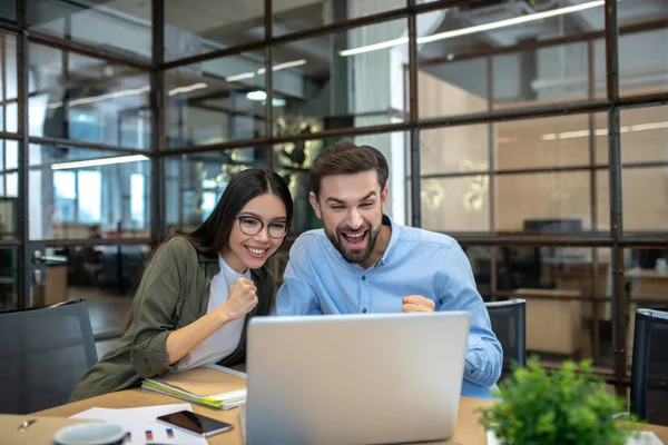 Baard jongeman en zijn vrouwelijke collega op zoek enthousiast — Stockfoto