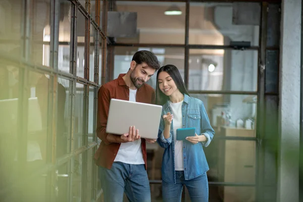 Hombre guapo barbudo con una camisa marrón discutiendo asuntos de trabajo con su colega — Foto de Stock