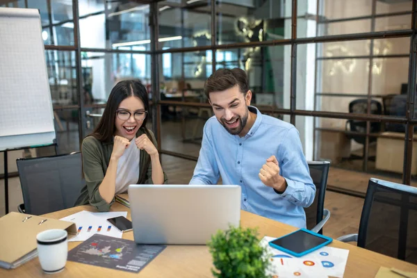 Baard jongeman en zijn vrouwelijke collega op zoek geïnteresseerd — Stockfoto