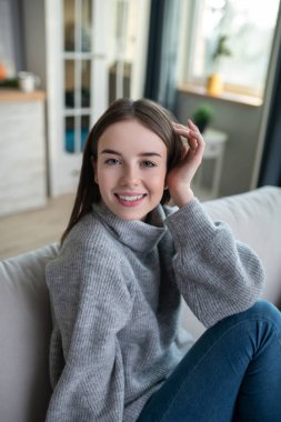 Young girl in a grey sweater spending time at home
