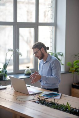 Genç işadamı projeyi online sohbette dizüstü bilgisayarında tartışıyor.