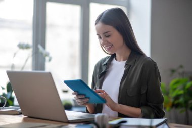 Elinde tabletle başarılı bir genç kız..